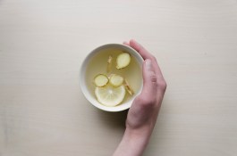 Public domain image of a hand holding a bowl of lemon water.